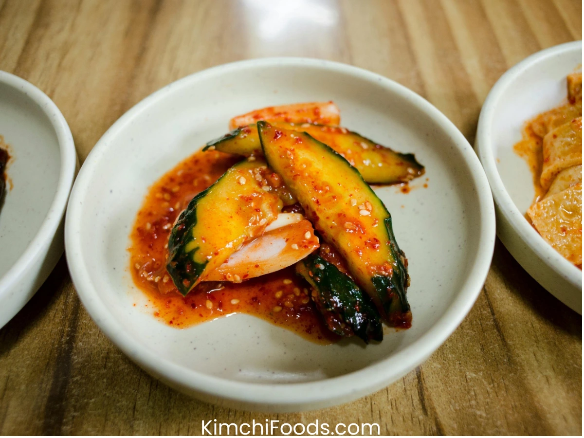 cucmber kimchi in a white bowl placing on the wooden table