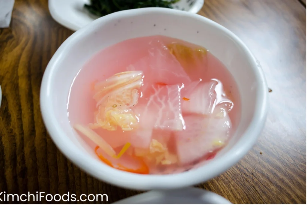 radish kimchi in a white bowl on the wooden table