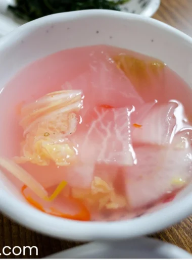 radish kimchi in a white bowl on the wooden table